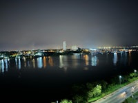 a view of a city at night with a river in the background